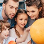 family-exploring-solar-system-model-for-school-project.jpg